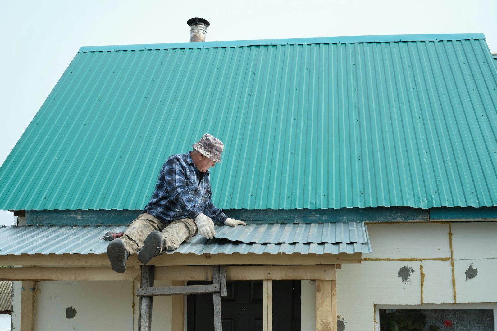 A seasoned individual focuses on roofing work, a skill crucial in ensuring safe and durable living