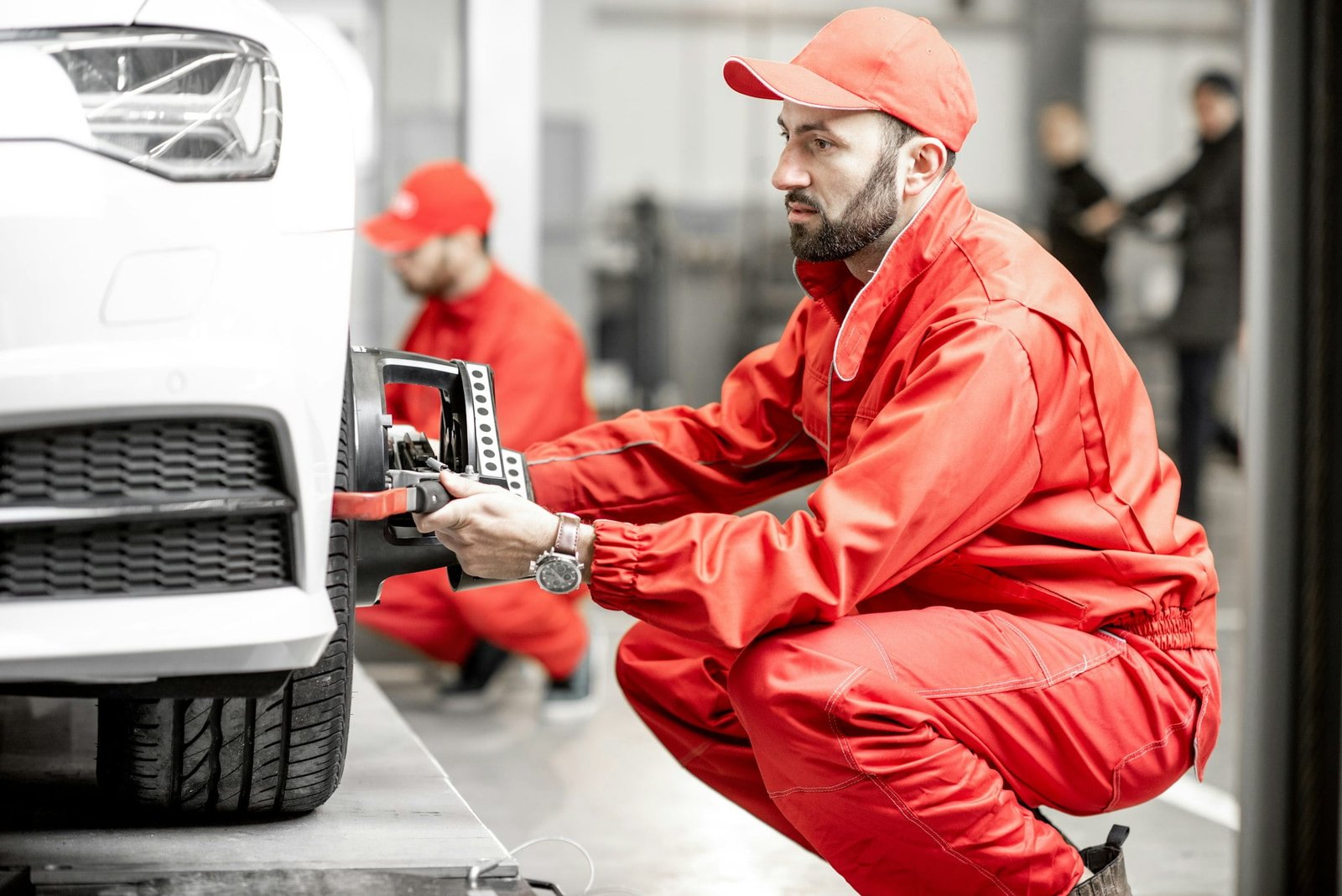 Auto mechanics making wheel alignment at the car service