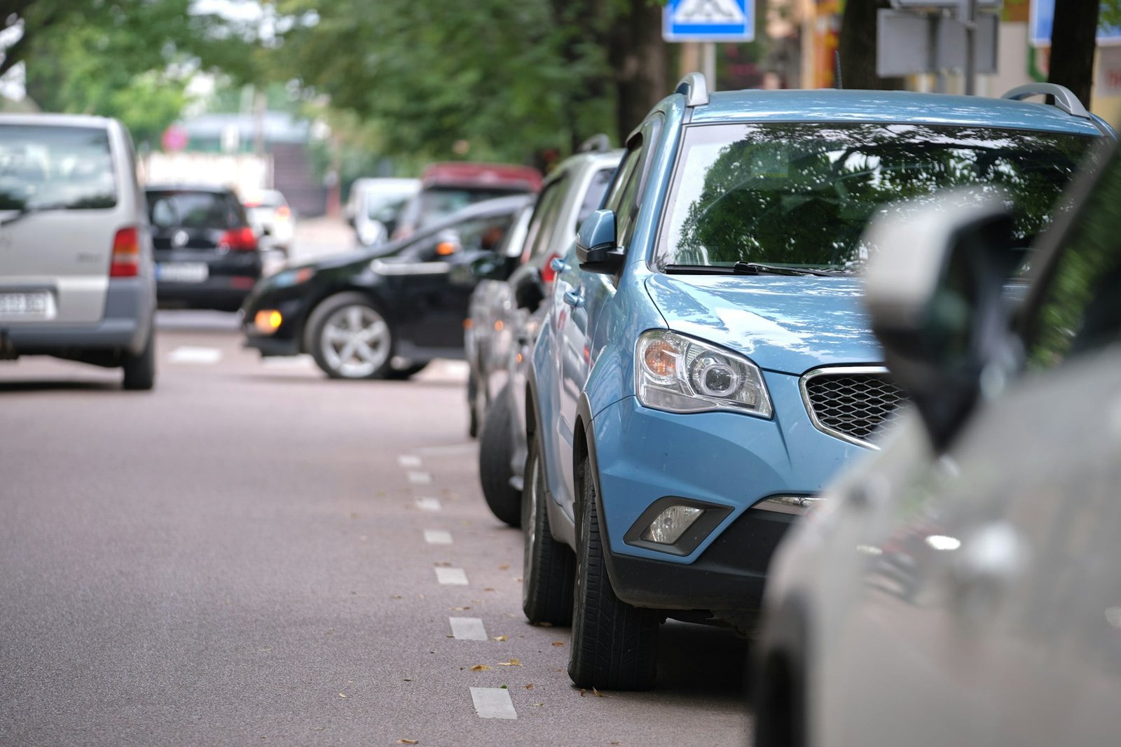 Cars parked in line on city street side. Urban traffic concept