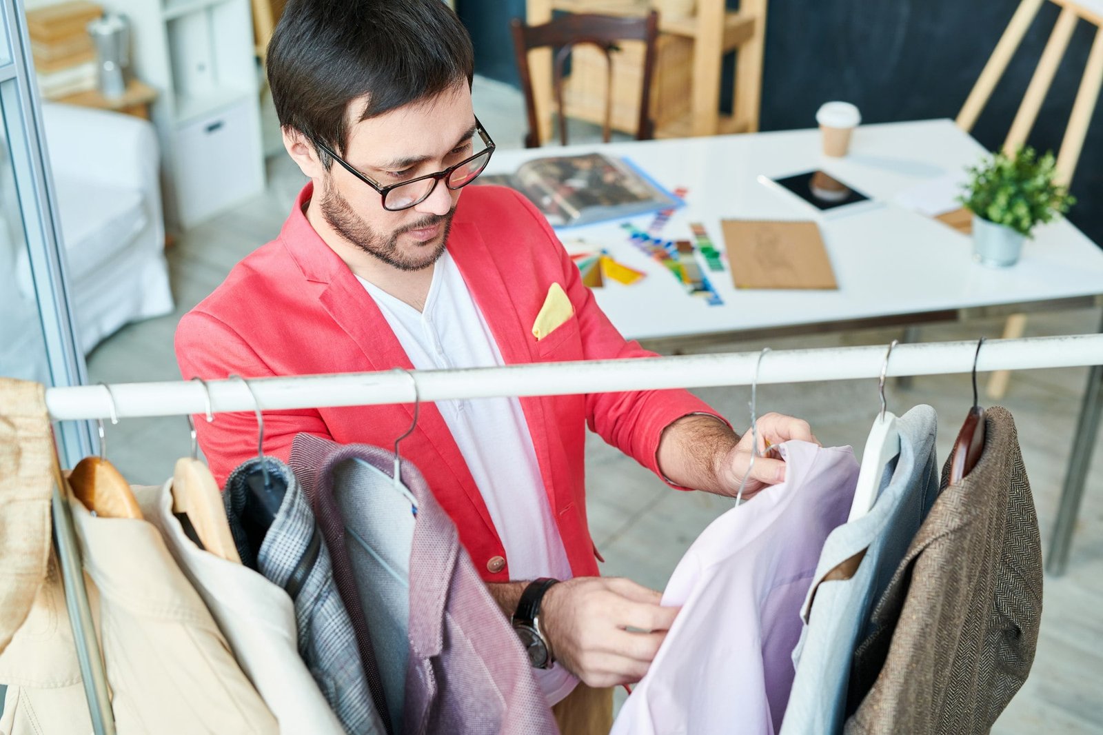 Designer exploring clothes on hangers