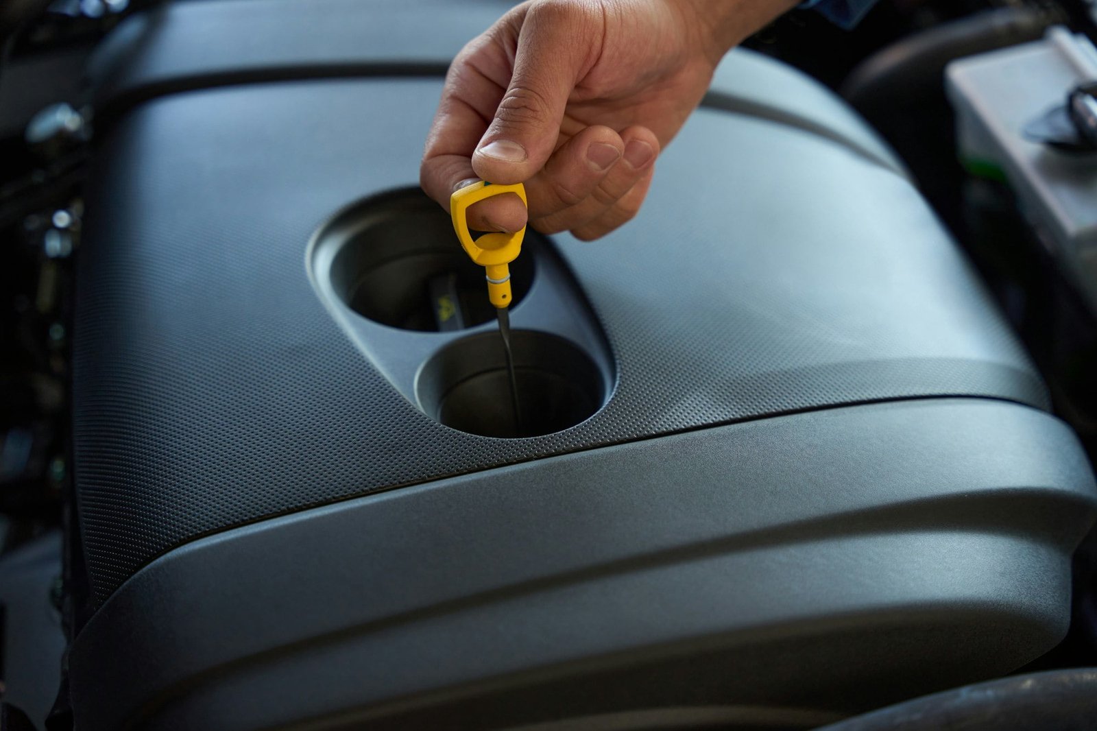 Driver checks the oil level in the car