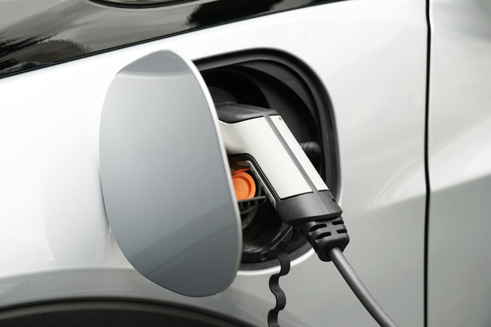 EV or Electric car at charging station plugged in with power supply cable