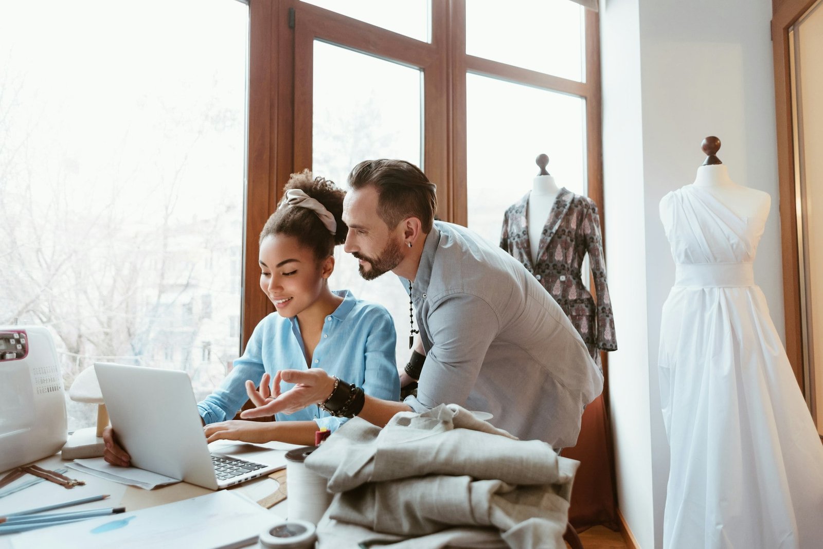 From paper to laptop. Man and woman at design studio