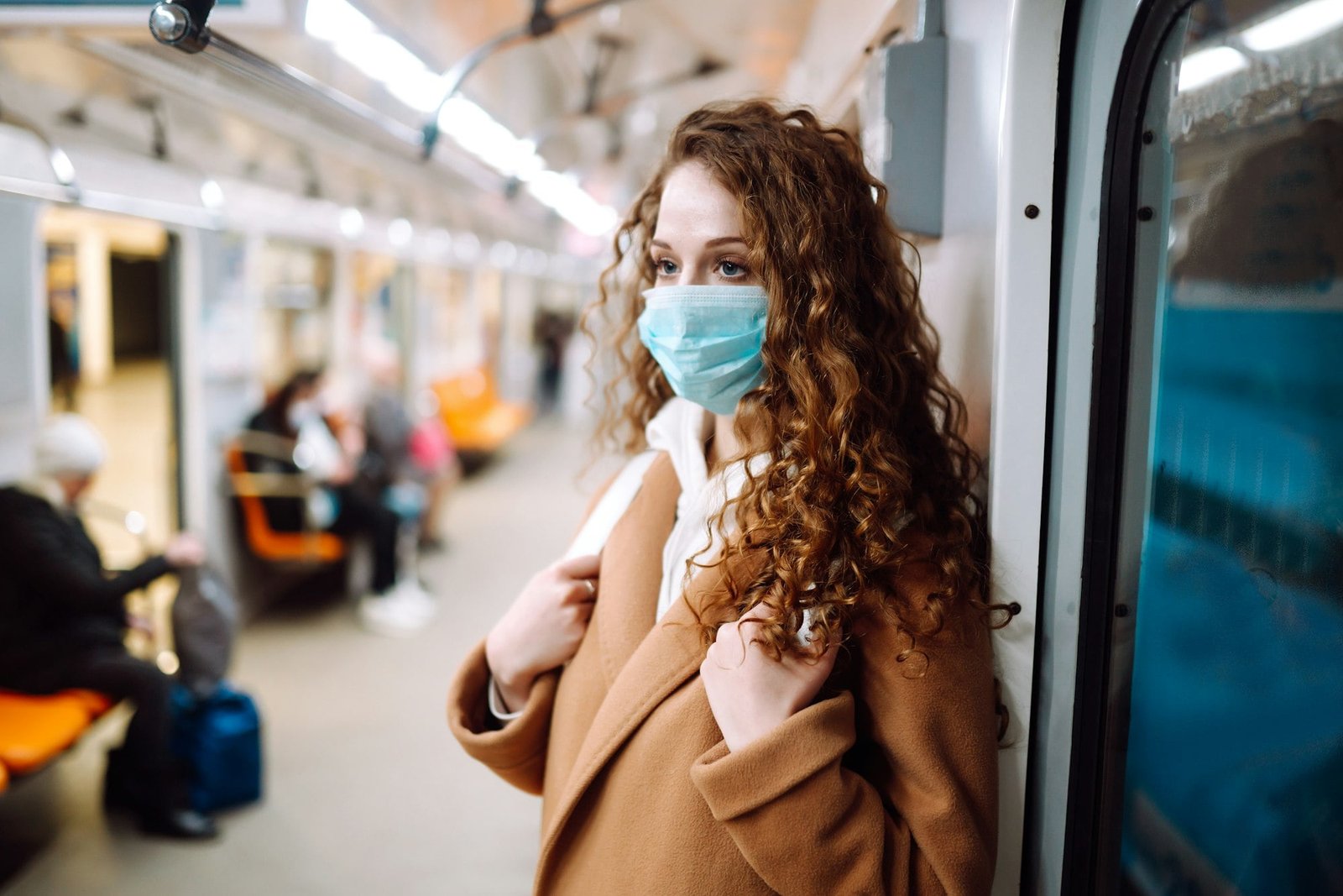 Girl in protective sterile medical mask in the subway car. Woman, wear face mask, protect of virus