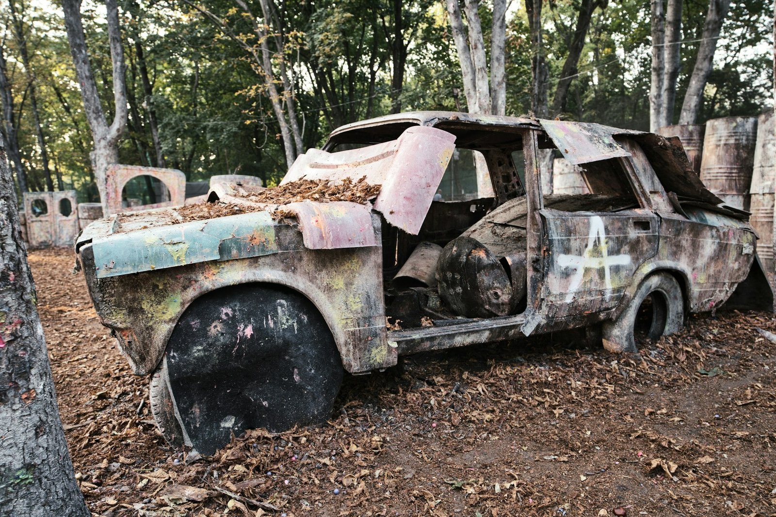 Old rusty and abandoned car at the paintball base