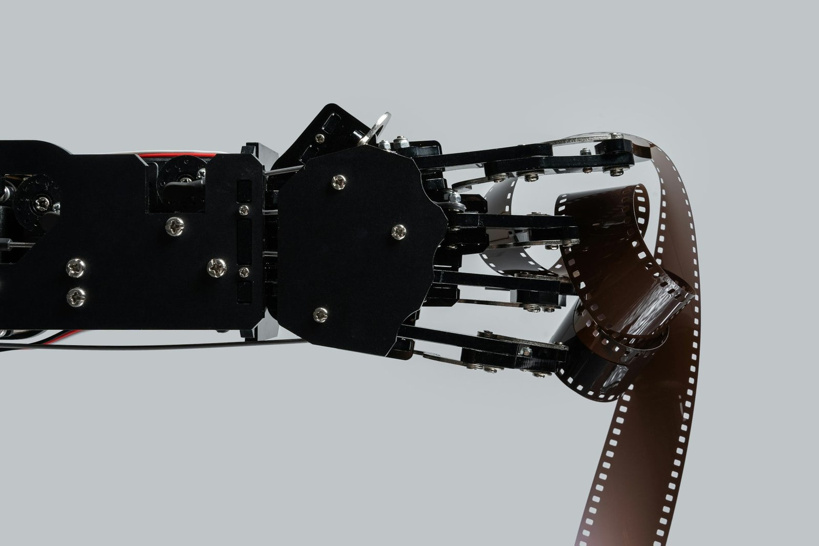 Real robotic hand with film stock. Concept of AI in motion picture and photography industry