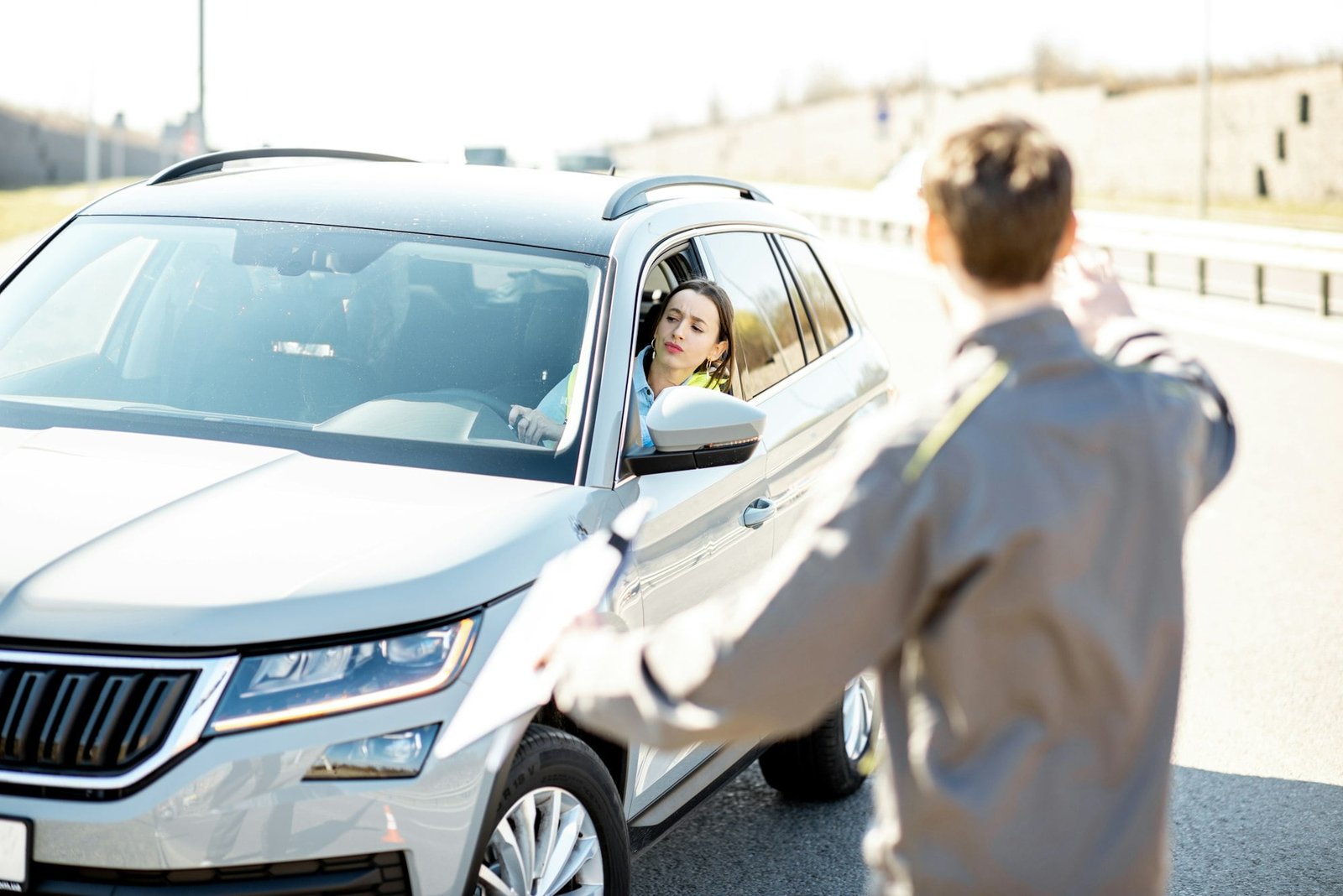 Road assistance worker helping to drive for a young woman