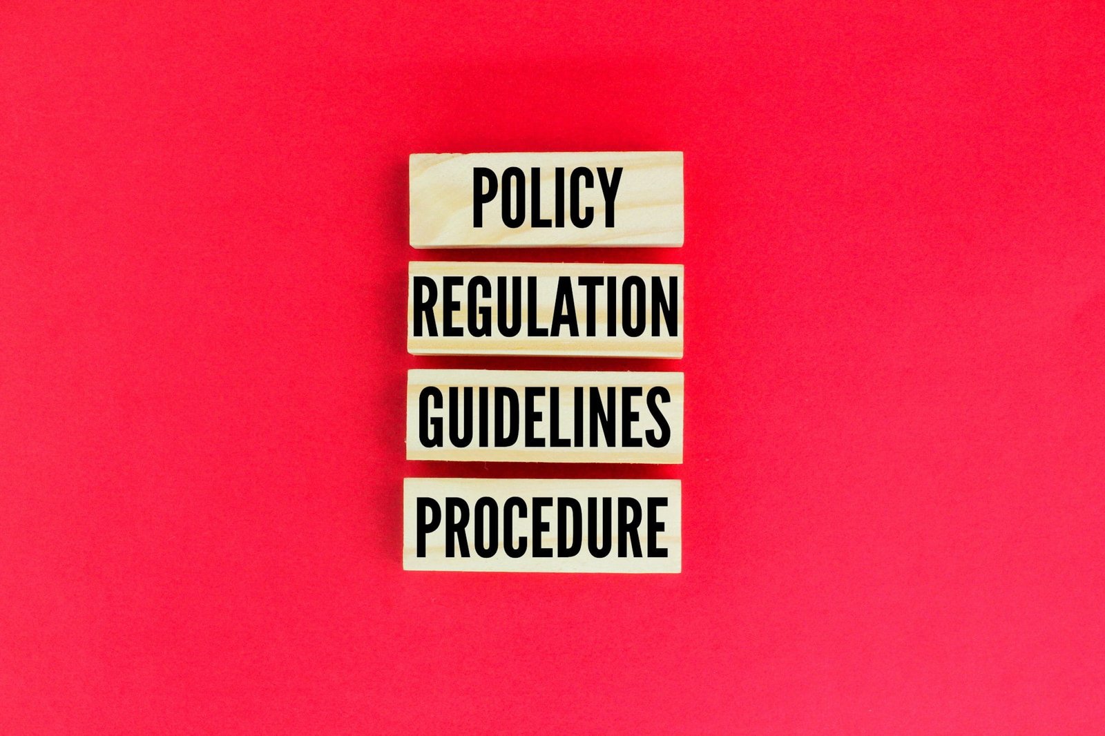 wooden arrangement with the words Policy Regulation Guidelines Procedure.