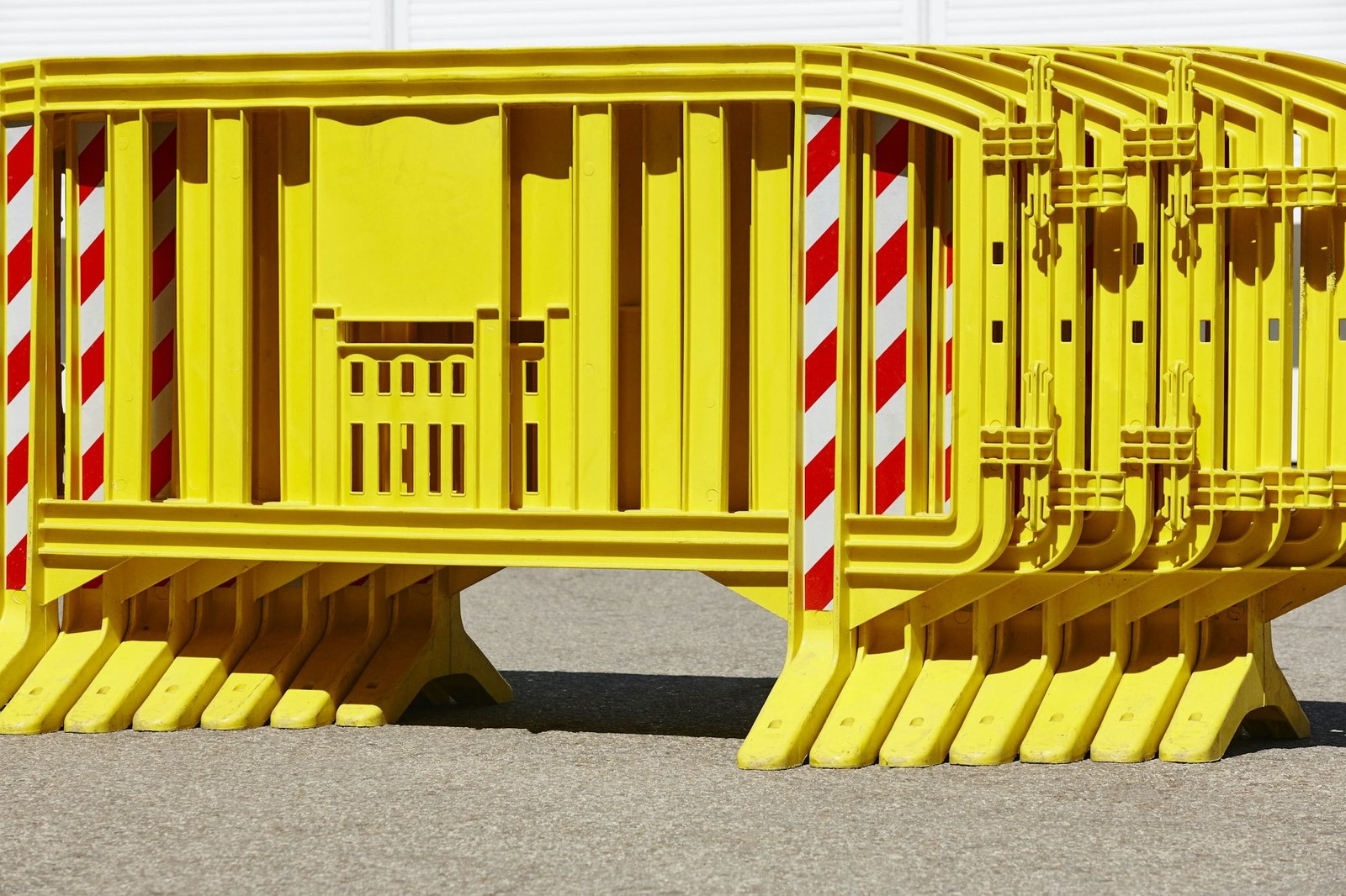 Yellow plastic barrier fence over an asphalt road. Security