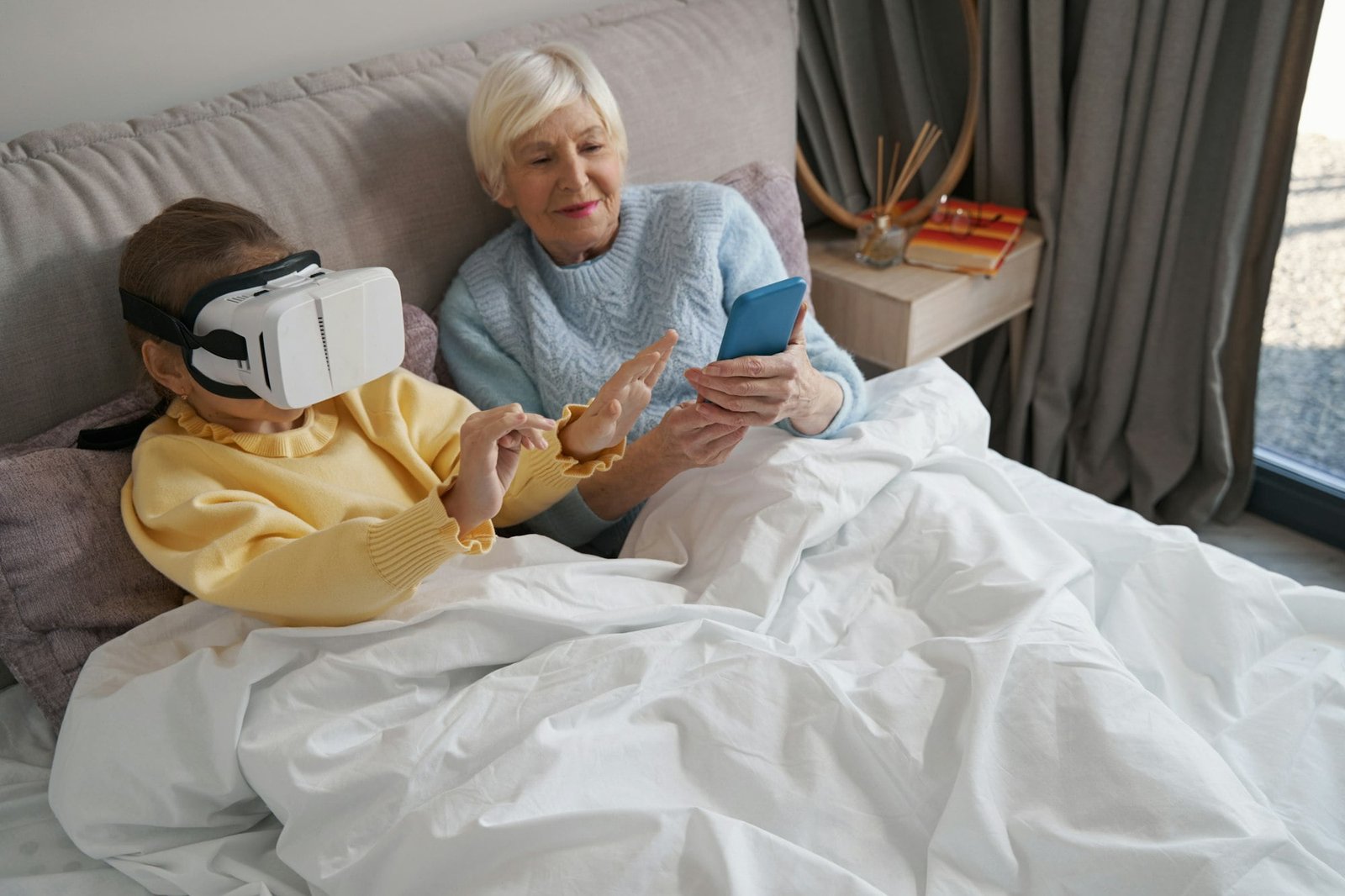 Young granddaughter and her grandma experiencing virtual reality at home