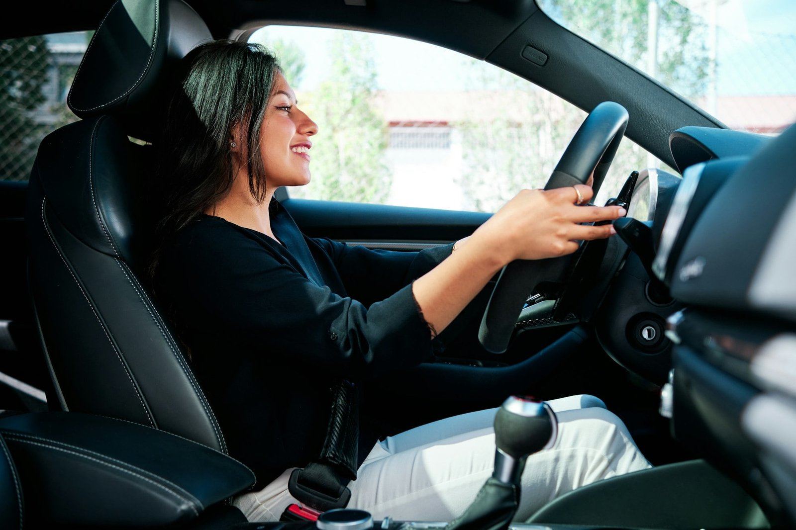 young latin woman driving luxury car