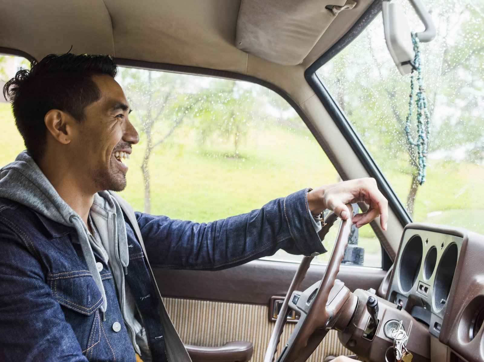 Young man in a car behind the steering wheel, driving.